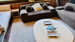 A modern living room with a sofa, a small side table, and a round coffee table with magazines.