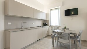 Une cuisine moderne équipée d’une cuisinière intégrée, d’un évier et d’un coin repas avec une table et des chaises.