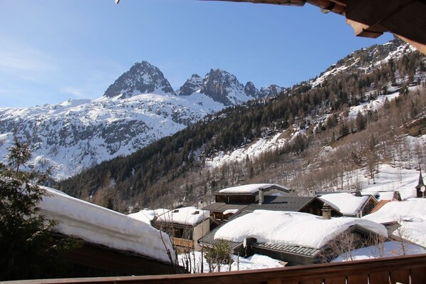 Un village de montagne aux bâtiments enneigés, offrant une vue dégagée sur les sommets environnants.