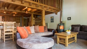 Ein gemütliches Wohnzimmer mit Kamin, Holzmöbeln und einer Treppe.