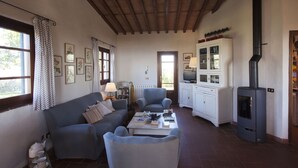 A cozy living room with a sofa, armchairs, a coffee table, a fireplace, and a television. - Casa Pedona (Camaiore)