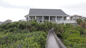 A beachfront house with a covered porch and a staircase leading to a balcony. - Come feel the "SEA BREEZE" - Minimum 2 week rental starting on Sundays (Emerald Isle)