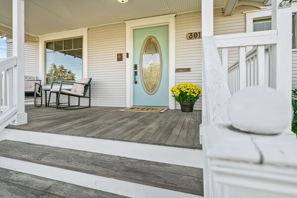 A porch with a light blue door, a mailbox, and a number '301' sign.