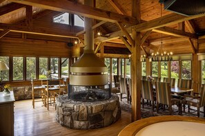 A rustic wooden interior with a stone fireplace, wooden dining table, and chairs. - Baywood Conference Center (Coraopolis)
