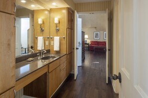 Un moderno baño de hotel con lavamanos doble, tocador y espejo.