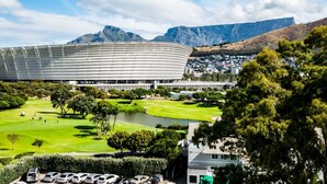 A stadium with a large, curved roof, surrounded by a golf course and residential buildings. - Magical Apartment w/Uninterrupted Ocean Views (Mouille Views) (Cape Town)