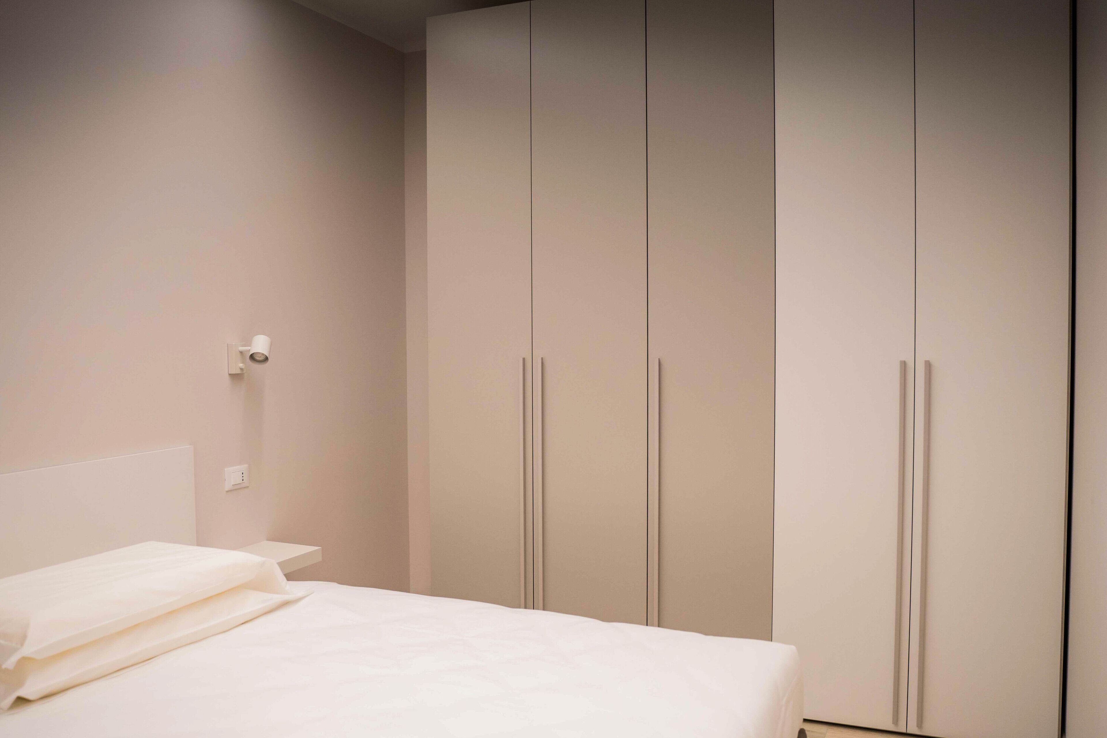 Une chambre à coucher avec un lit, une table de chevet et une armoire.