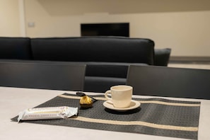 A table with a cup and a chocolate bar on a placemat.