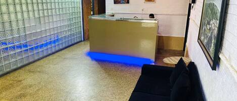 A reception area with a counter, a couch, and a wall with a patterned design.