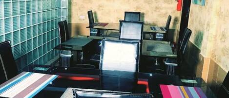 A conference room with a large table, multiple chairs, a flat-screen TV, and an air conditioning unit on the wall.