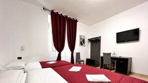 A hotel room with two beds, a desk, a TV, and a window with curtains. - Hotel Domus Termini (Rome)