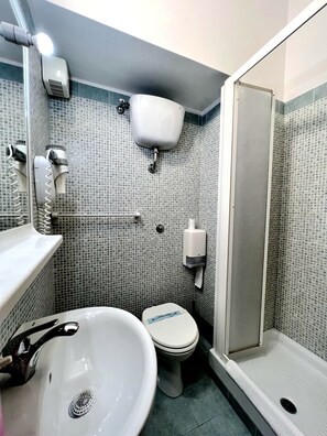 A bathroom with a white sink, toilet, and a shower area. - Hotel Domus Termini (Rome)