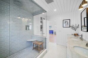 Een bad/douchecombinatie, een haardroger, handdoeken, zeep