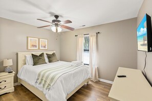 Relax in this serene bedroom with a large bed, nightstand, and flat-screen TV.