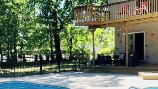 Un espace piscine doté d’une terrasse en bois et d’une clôture de protection.