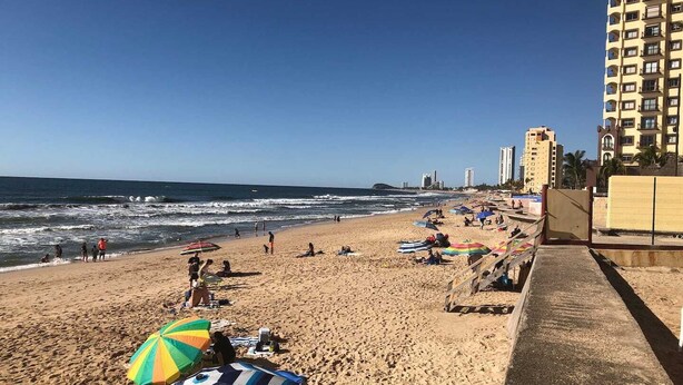 A beach with umbrellas and people. - Departamentos MDR (Mazatlán)