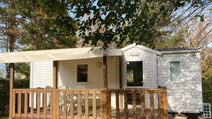 A mobile home with a wooden deck and a covered patio area. - Mobile home 6 persons. (Attigny)