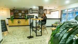 Un interior moderno con un mostrador de recepción, un ordenador portátil sobre una mesa y un reloj grande en la pared.