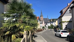A street with traditional European architecture, including a church with a tall spire. - Romantic vacation in the wine village of Kiedrich (Kiedrich)