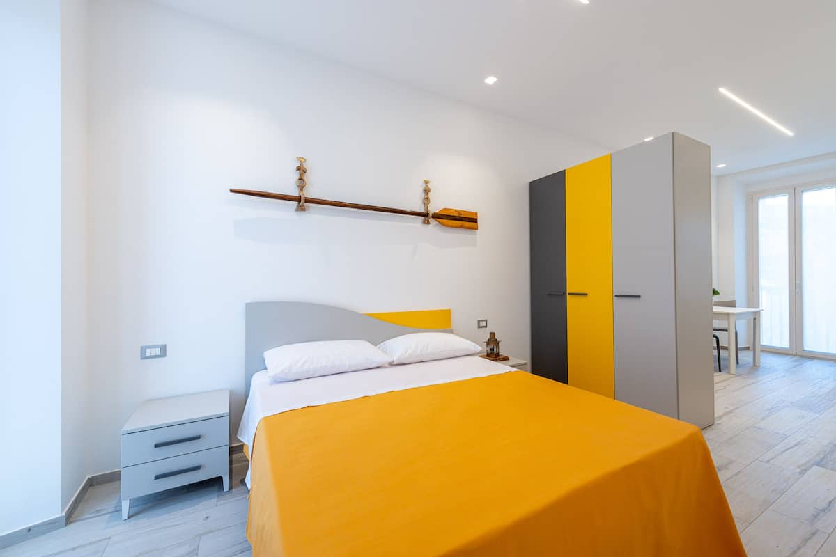 Une chambre à coucher moderne avec un lit, une table de chevet, une armoire et un bureau.