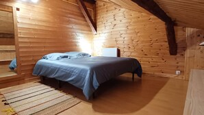 Ein gemütlicher Holzraum mit einem Bett, einem kleinen Tisch und einem Regal.