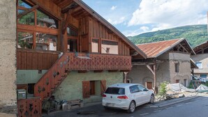 Ein traditionelles Holzhaus mit einem geparkten Auto davor.