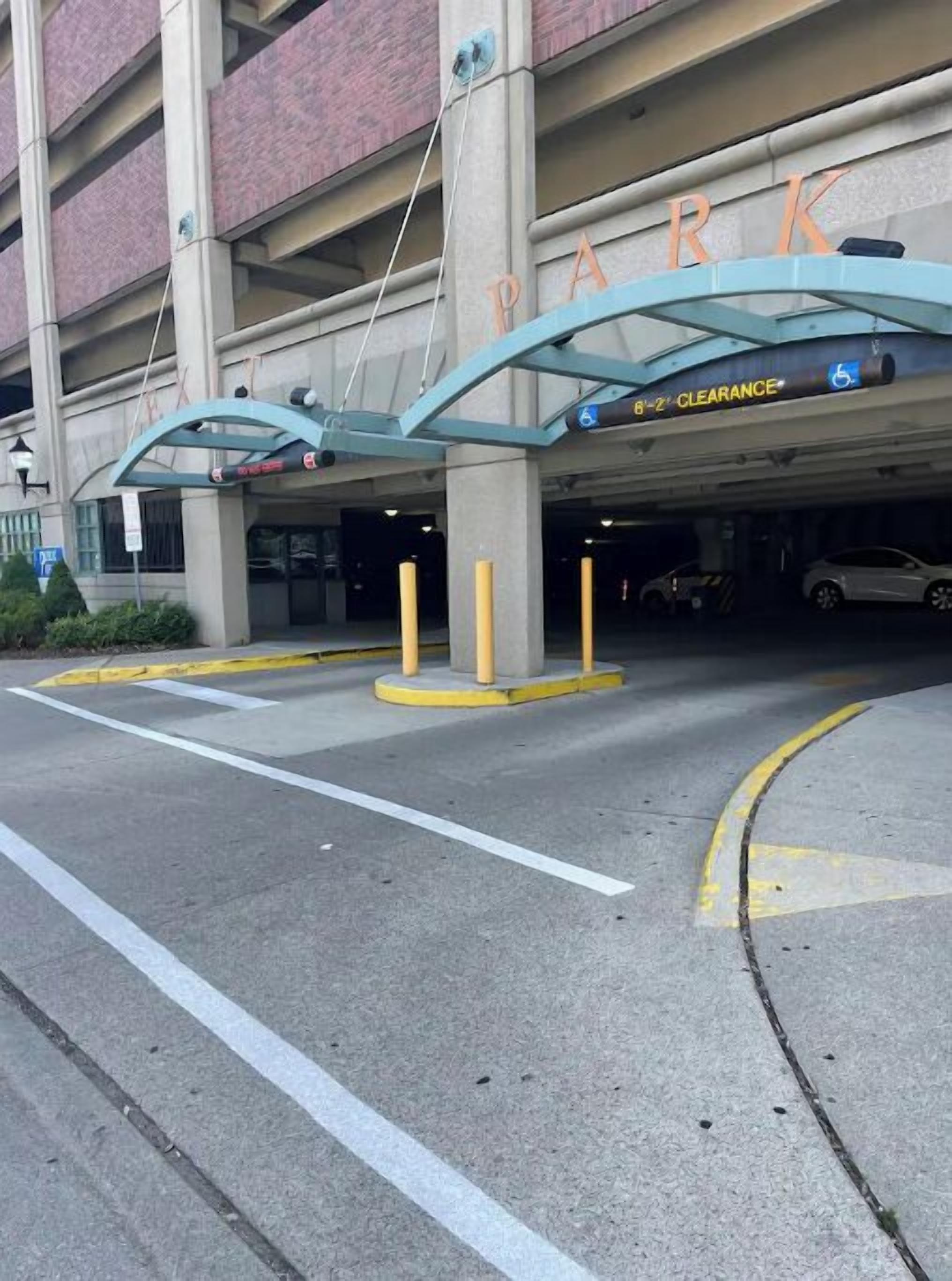 A parking garage entrance with a clear sign indicating 'CLEARANCE' and a disabled parking symbol.