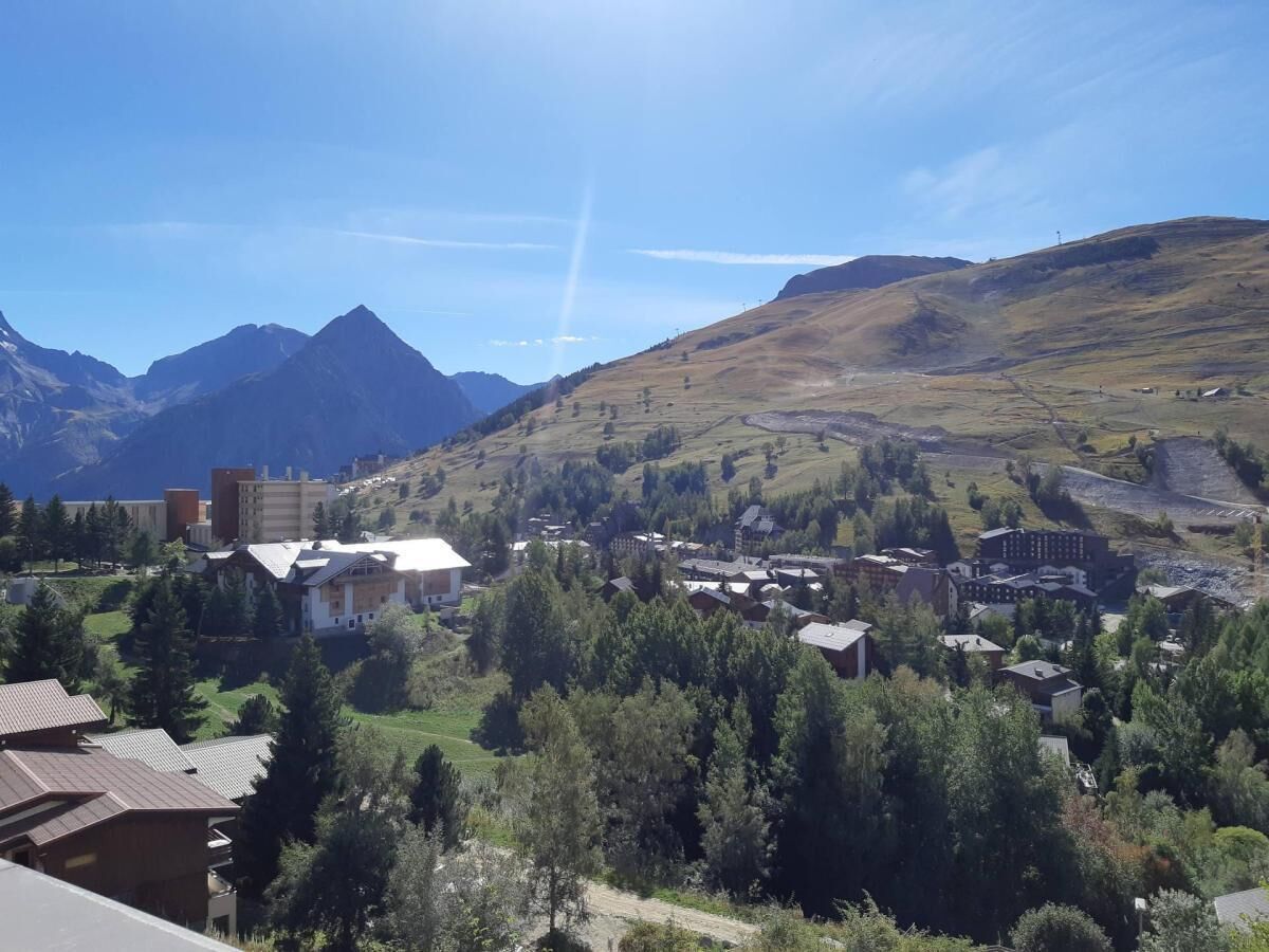 Un paysage montagneux avec un village, des bâtiments et une église imposante.