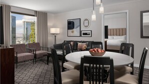 A hotel room with a dining area, a sofa, a bed, and a city view. - 1BR Villa Walk to Las Vegas Strip - Marriott Grand Chateau - Full Kitchen + Pool (Las Vegas)