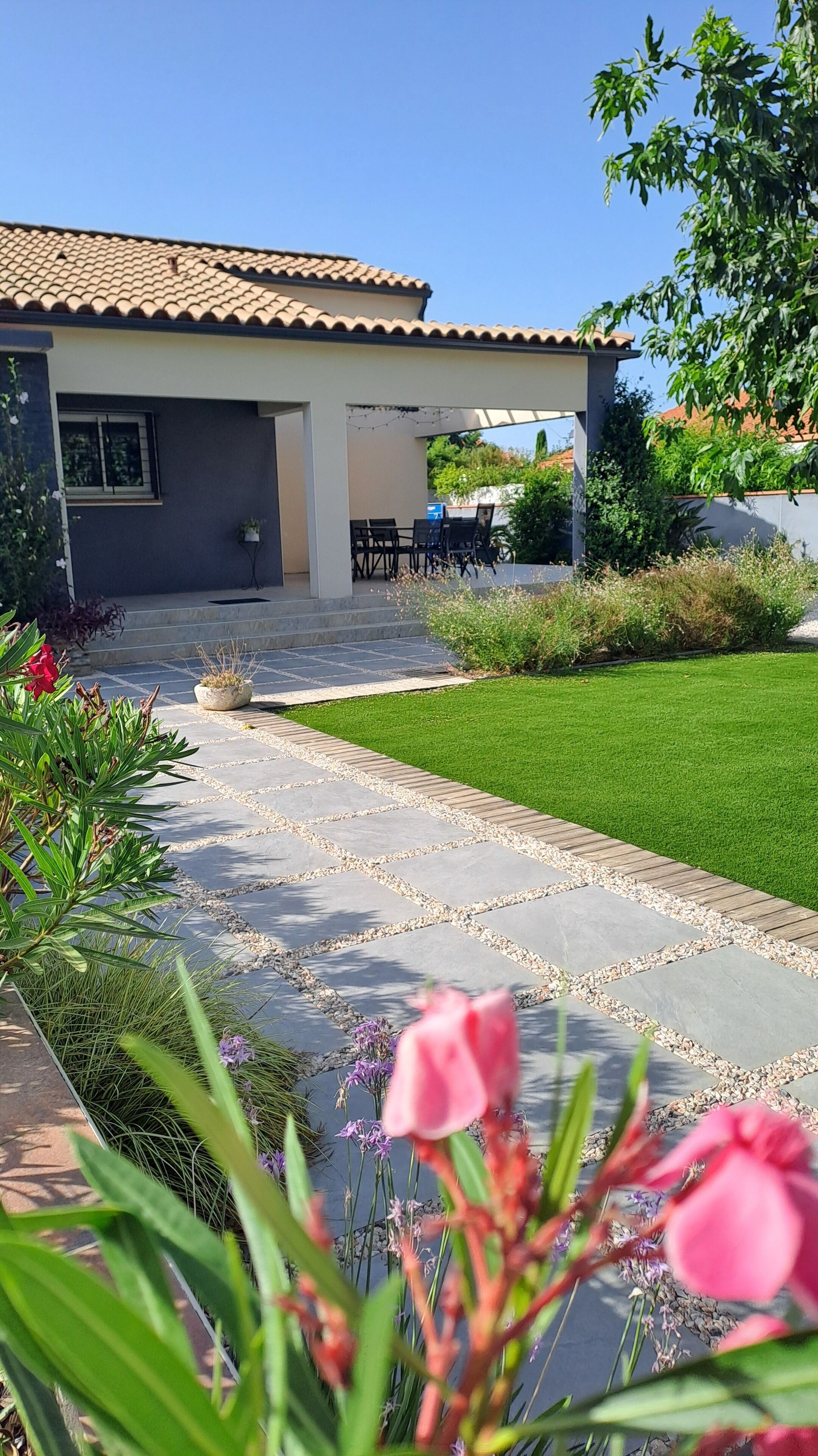 A patio with a stone pathway leading to a covered seating area.