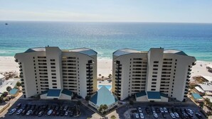 A beachfront hotel with two symmetrical buildings, a parking lot, and a view of the ocean. - Gulf-Front Condo | Private Balcony, 3 Pools (1 Heated) (Panama City Beach)