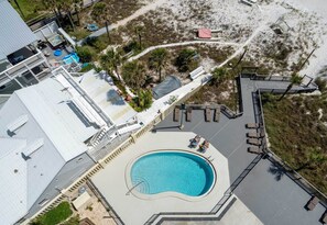 Un resort con piscina central, zona de playa y terraza cubierta.