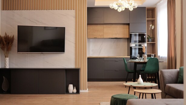 A modern living room with a flat-screen TV, a fireplace, and a dining area with a table and chairs.