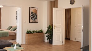 A modern living room with a sofa, a coffee table, and a plant arrangement.