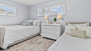 A bedroom with two beds, a nightstand, and a dresser. - Lovely 2-Bedroom Condo, Close to Burlington/Airport! (South Burlington)