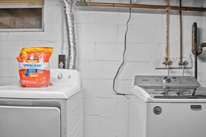 Un espace buanderie comprenant un lave-linge et un sèche-linge, un sac de lessive UltraClean et un sèche-linge Maytag.