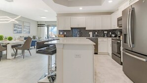 A modern kitchen with white cabinets, stainless steel appliances, and a central island. - SUMMER SALE! Storey Lake 3BDRM (Kissimmee)