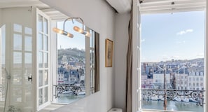 Ein Zimmer mit großem Fenster zum Hafenblick, einer Dusche und einem gerahmten Bild an der Wand.