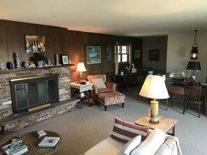 Un salón acogedor con chimenea, asientos cómodos y elementos decorativos.
