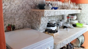 A kitchen with a marble countertop, a white refrigerator, and a patterned backsplash. - Hostal La Pianista TRINIDAD (Trinidad)