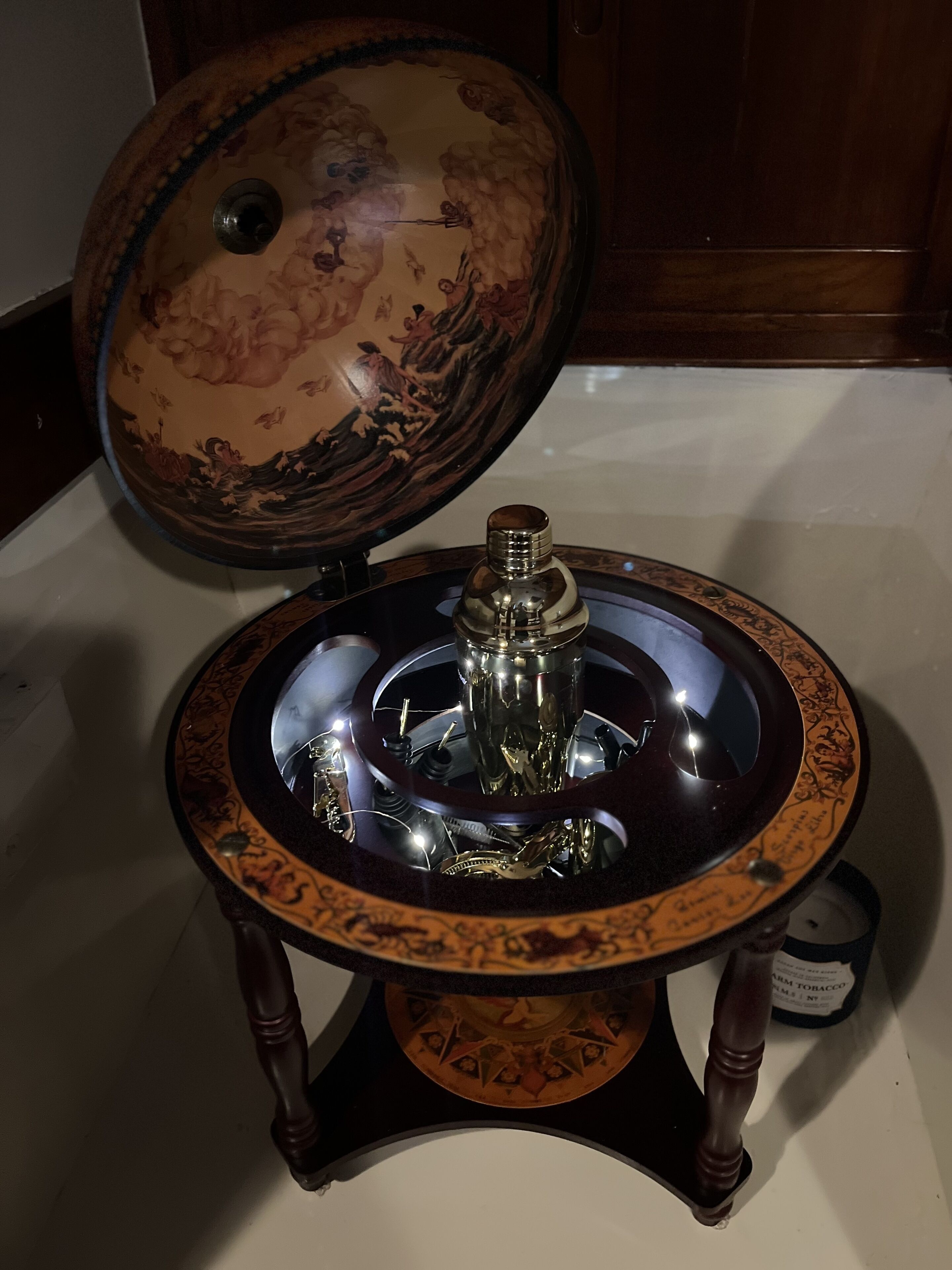 A vintage rotary phone with a decorative base and a glass dome.
