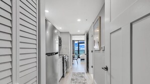A hallway with a kitchen area, a dining area, and a view of the sky. - Breakers Tower 1BR Oceanfront Condo (Myrtle Beach)