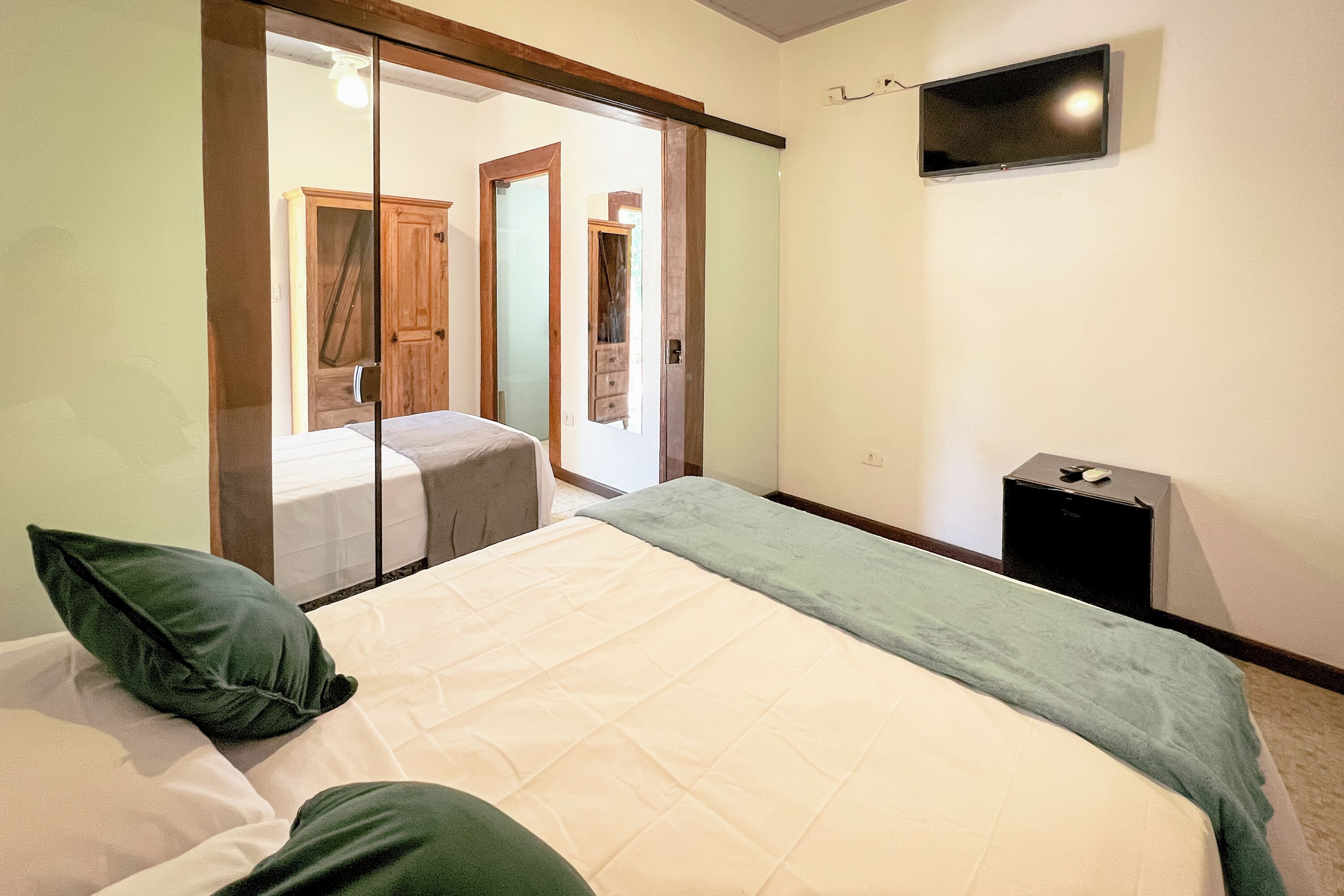 Un dormitorio con cama, televisor y armario.