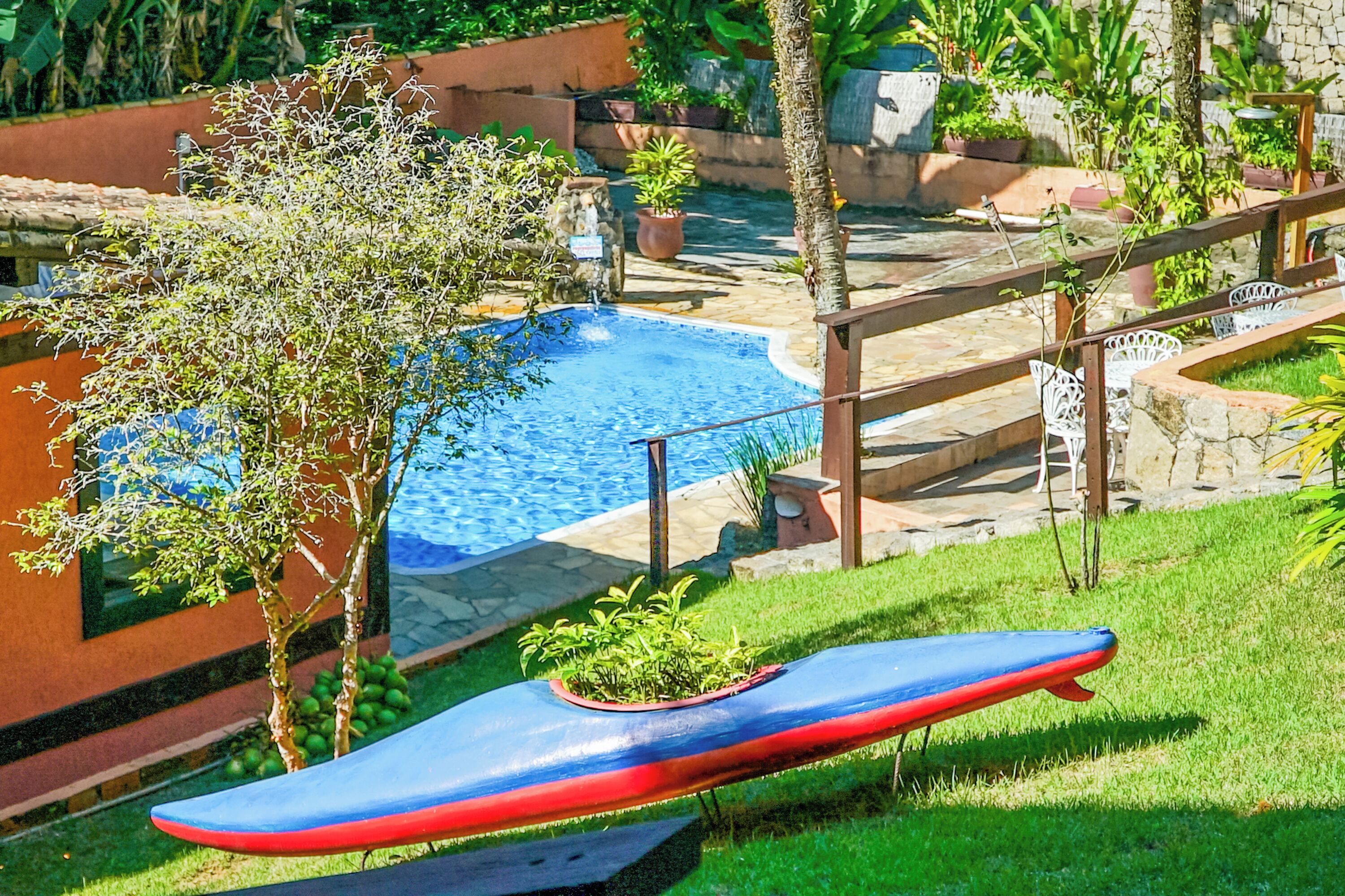 A swimming pool with a wooden deck and a red and blue floating dock.