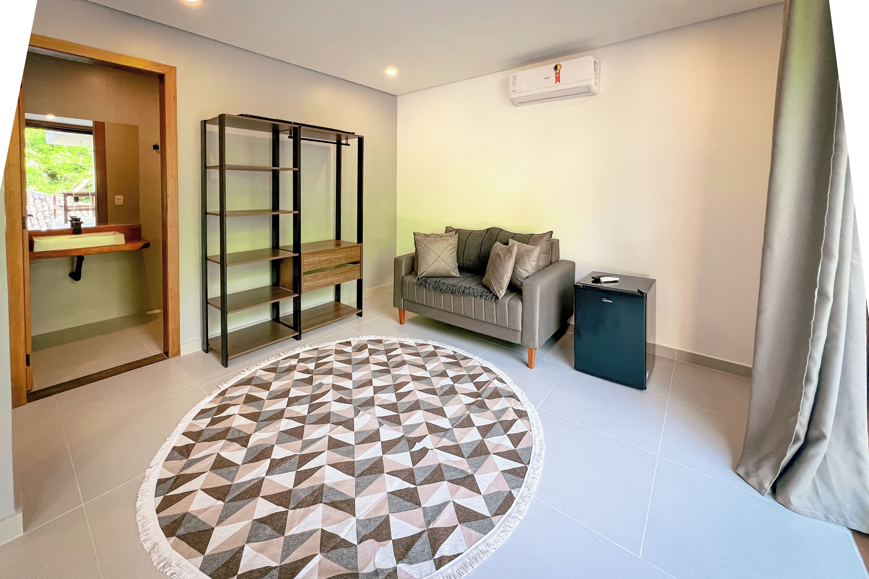 A modern living room with a sofa, a coffee table, and a geometric patterned rug.