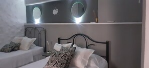 Un dormitorio con una cama, dos mesitas de noche y una estantería de pared con adornos.