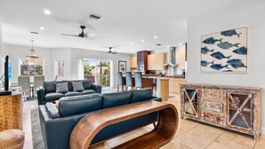 A spacious living area with a sectional sofa, a wooden coffee table, and a rustic cabinet. - Luxury Townhome with a Rooftop Deck! - Changing Channels (Siesta Key)