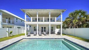 Una casa de dos pisos con una piscina delantera.