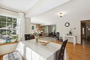 A spacious living room with a dining area, a fireplace, and a view of the outdoors.