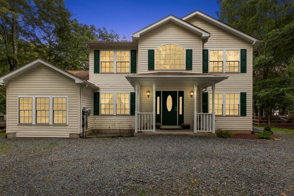 A two-story house with a front porch, a garage, and a driveway.